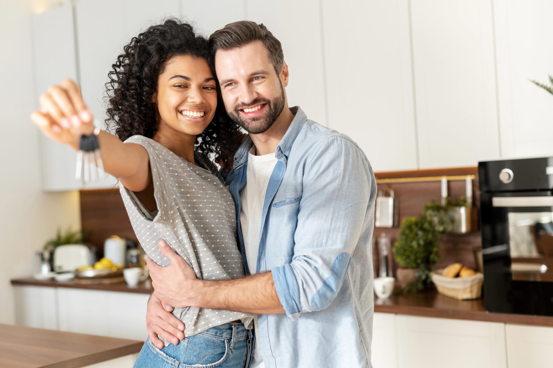 Young Interracial Married Couple Homeowners Smiling Showing Keys From A Young Interracial Married Couple Homeowners Smiling Showing Keys From A